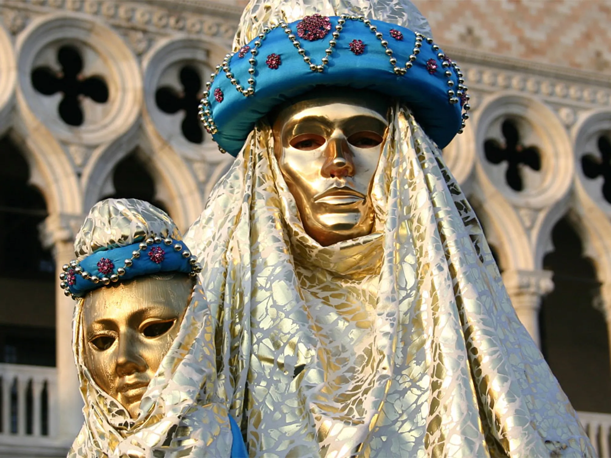 Costumed figures in gold masks at Carnevale in Venice