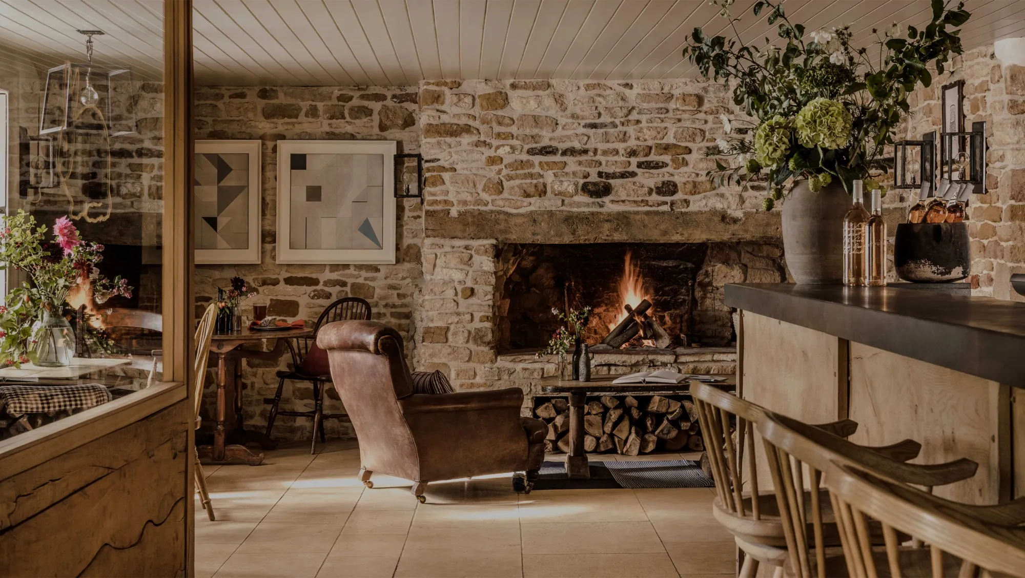 A cosy Cotswold restaurant interior with an open fire
